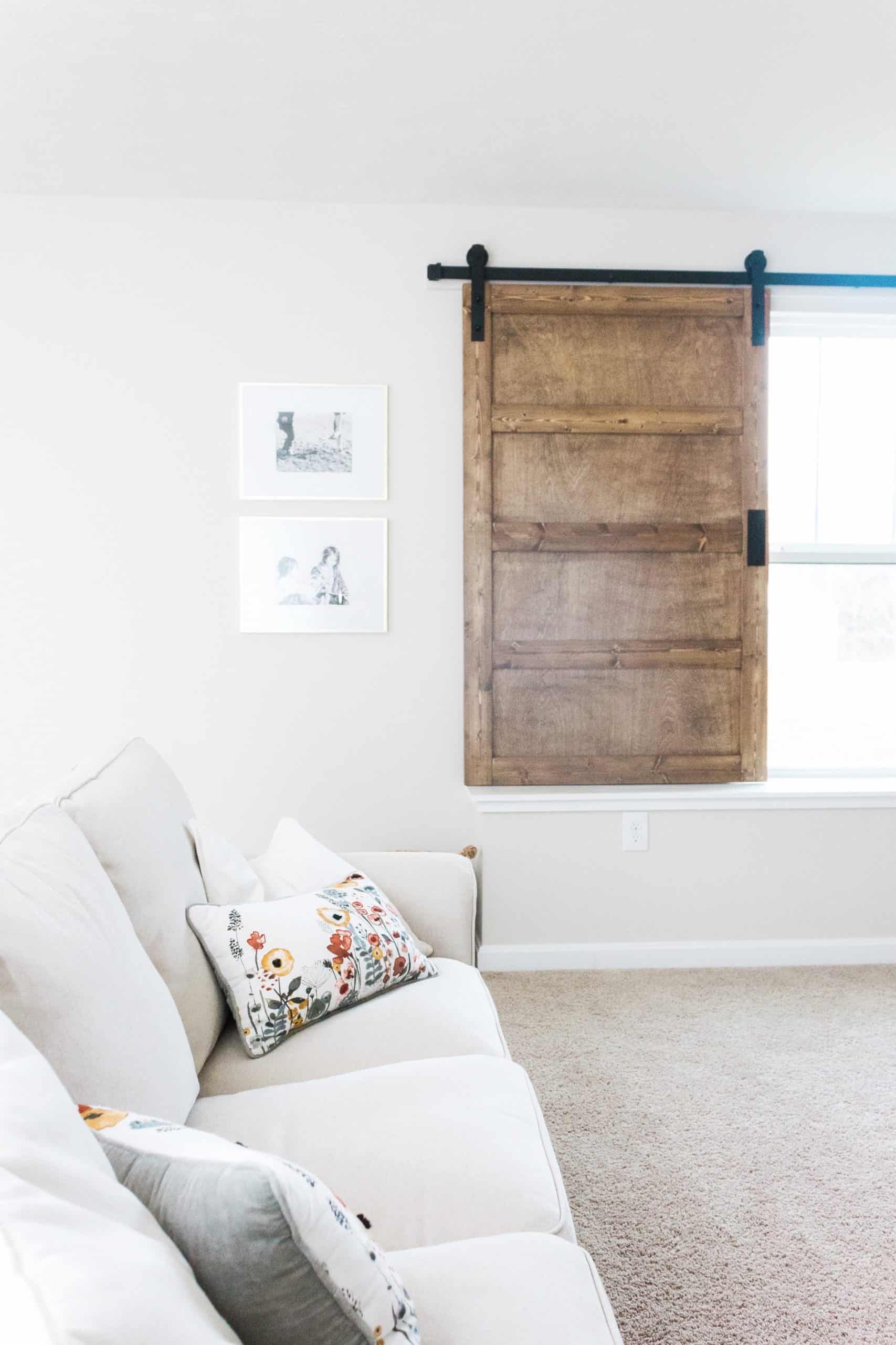 Want to build a modern farmhouse-inspired sliding barn door window covering? Head to www.freeandunfettered.com for the complete tutorial. #diyhome #modernfarmhouse #slidingbarndoor #diyhomedecor 